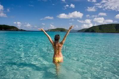 6192655-woman-in-tropical-beach-water-with-yellow-bikini-and-arms-outstretched-on-vacation-in-caribbean.jpg